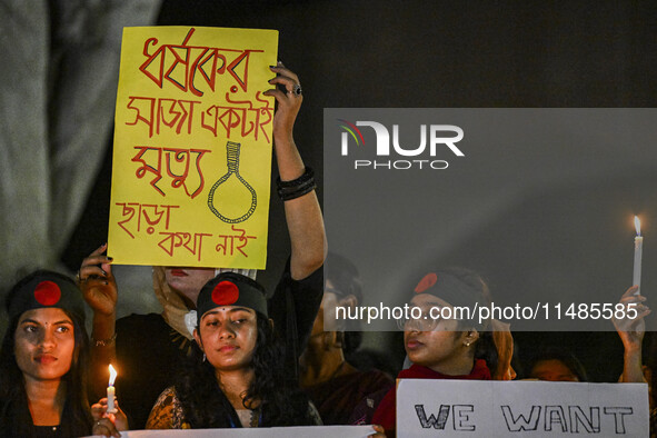 Bangladeshi women protesters are holding candles and placards during the protest against rape in Dhaka, Bangladesh, on August 17, 2024. Wome...