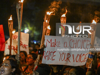 Bangladeshi women protesters are holding torches and placards during the protest against rape in Dhaka, Bangladesh, on August 17, 2024. Wome...