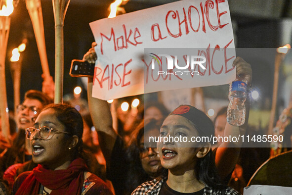 Bangladeshi women protesters are holding torches and placards during the protest against rape in Dhaka, Bangladesh, on August 17, 2024. Wome...