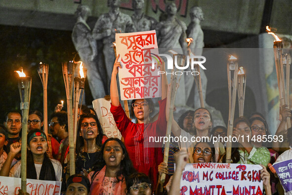 Bangladeshi women protesters are holding torches and placards during the protest against rape in Dhaka, Bangladesh, on August 17, 2024. Wome...