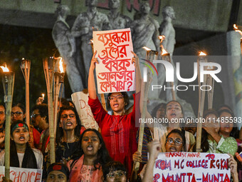 Bangladeshi women protesters are holding torches and placards during the protest against rape in Dhaka, Bangladesh, on August 17, 2024. Wome...