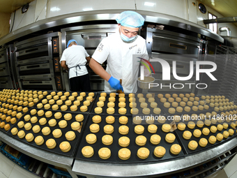 A worker is producing mooncakes at a food workshop in Hai'an, Jiangsu province, China, on August 16, 2024. (