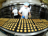 A worker is producing mooncakes at a food workshop in Hai'an, Jiangsu province, China, on August 16, 2024. (