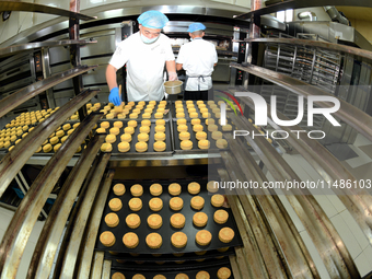 A worker is producing mooncakes at a food workshop in Hai'an, Jiangsu province, China, on August 16, 2024. (