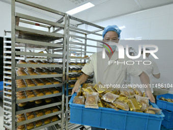 A worker is producing mooncakes at a food workshop in Hai'an, Jiangsu province, China, on August 16, 2024. (