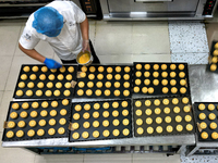 A worker is producing mooncakes at a food workshop in Hai'an, Jiangsu province, China, on August 16, 2024. (