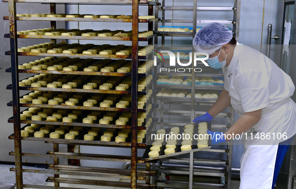 A worker is producing mooncakes at a food workshop in Hai'an, Jiangsu province, China, on August 16, 2024. 