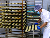 A worker is producing mooncakes at a food workshop in Hai'an, Jiangsu province, China, on August 16, 2024. (