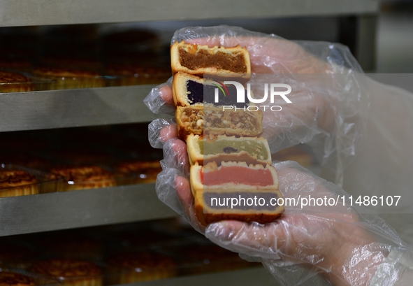 A worker is producing mooncakes at a food workshop in Hai'an, Jiangsu province, China, on August 16, 2024. 