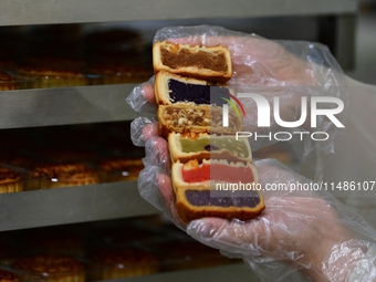 A worker is producing mooncakes at a food workshop in Hai'an, Jiangsu province, China, on August 16, 2024. (