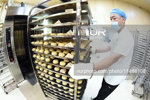 A worker is producing mooncakes at a food workshop in Hai'an, Jiangsu province, China, on August 16, 2024. 