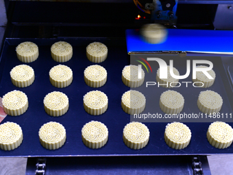 A worker is producing mooncakes at a food workshop in Hai'an, Jiangsu province, China, on August 16, 2024. (