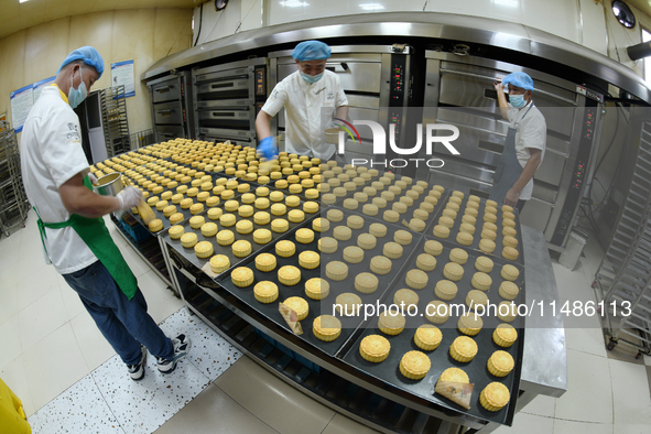 A worker is producing mooncakes at a food workshop in Hai'an, Jiangsu province, China, on August 16, 2024. 