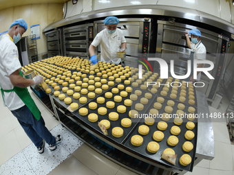 A worker is producing mooncakes at a food workshop in Hai'an, Jiangsu province, China, on August 16, 2024. (