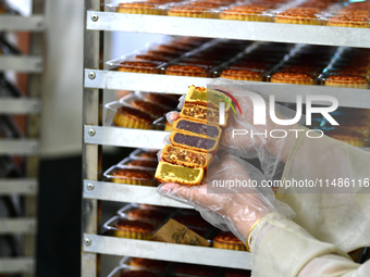 A worker is producing mooncakes at a food workshop in Hai'an, Jiangsu province, China, on August 16, 2024. (