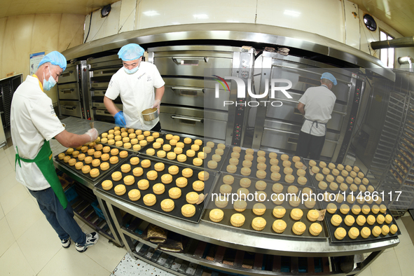 A worker is producing mooncakes at a food workshop in Hai'an, Jiangsu province, China, on August 16, 2024. 