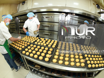 A worker is producing mooncakes at a food workshop in Hai'an, Jiangsu province, China, on August 16, 2024. (