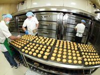 A worker is producing mooncakes at a food workshop in Hai'an, Jiangsu province, China, on August 16, 2024. (