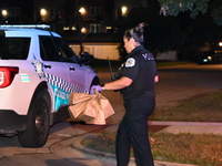 Evidence bags are being collected and put in the back of a Chicago police vehicle. A 28-year-old male victim is being shot numerous times an...