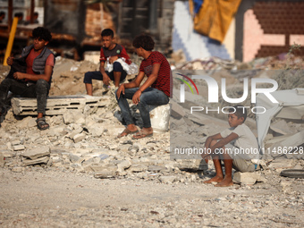 Palestinians are inspecting the site of an Israeli strike in al-Zawayda in the central Gaza Strip on August 17, 2024, amid the ongoing confl...