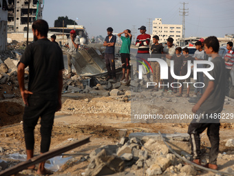 Palestinians are inspecting the site of an Israeli strike in al-Zawayda in the central Gaza Strip on August 17, 2024, amid the ongoing confl...