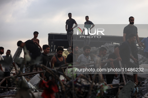 Palestinians are inspecting the site of an Israeli strike in al-Zawayda in the central Gaza Strip on August 17, 2024, amid the ongoing confl...