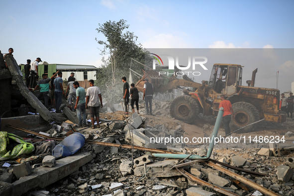 Palestinians are inspecting the site of an Israeli strike in al-Zawayda in the central Gaza Strip on August 17, 2024, amid the ongoing confl...