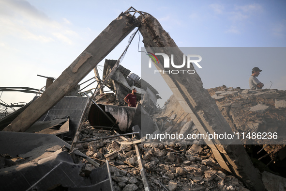 Palestinians are inspecting the site of an Israeli strike in al-Zawayda in the central Gaza Strip on August 17, 2024, amid the ongoing confl...