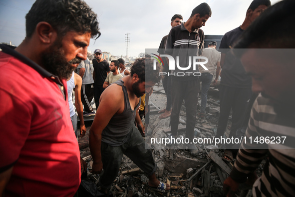 Palestinians are inspecting the site of an Israeli strike in al-Zawayda in the central Gaza Strip on August 17, 2024, amid the ongoing confl...