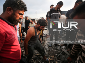 Palestinians are inspecting the site of an Israeli strike in al-Zawayda in the central Gaza Strip on August 17, 2024, amid the ongoing confl...