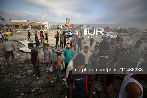 Palestinians are inspecting the site of an Israeli strike in al-Zawayda in the central Gaza Strip on August 17, 2024, amid the ongoing confl...