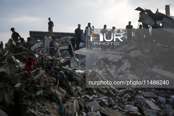 Palestinians are inspecting the site of an Israeli strike in al-Zawayda in the central Gaza Strip on August 17, 2024, amid the ongoing confl...