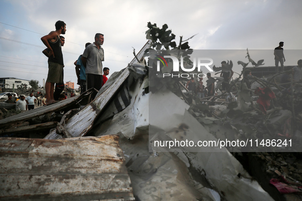 Palestinians are inspecting the site of an Israeli strike in al-Zawayda in the central Gaza Strip on August 17, 2024, amid the ongoing confl...