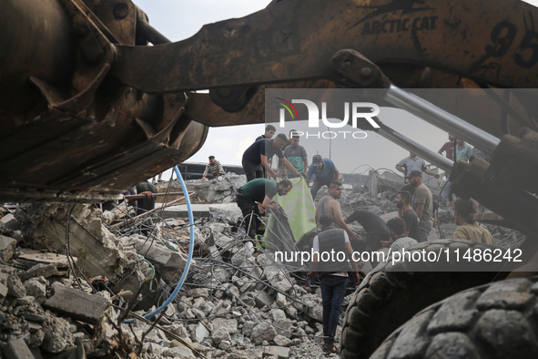 Palestinians are inspecting the site of an Israeli strike in al-Zawayda in the central Gaza Strip on August 17, 2024, amid the ongoing confl...