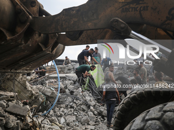 Palestinians are inspecting the site of an Israeli strike in al-Zawayda in the central Gaza Strip on August 17, 2024, amid the ongoing confl...