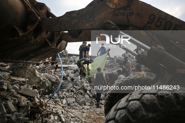 Palestinians are inspecting the site of an Israeli strike in al-Zawayda in the central Gaza Strip on August 17, 2024, amid the ongoing confl...