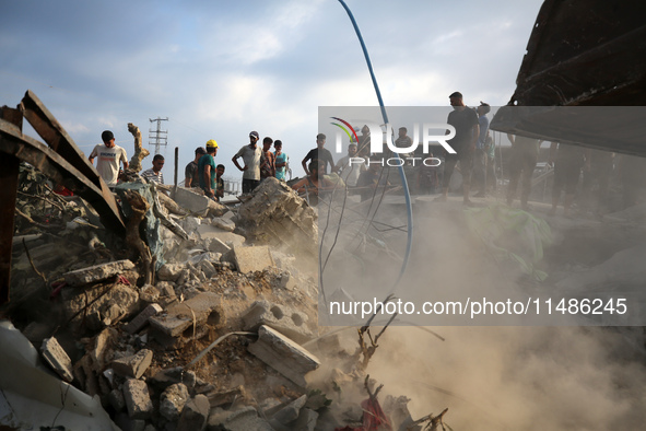 Palestinians are inspecting the site of an Israeli strike in al-Zawayda in the central Gaza Strip on August 17, 2024, amid the ongoing confl...