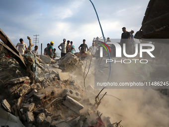 Palestinians are inspecting the site of an Israeli strike in al-Zawayda in the central Gaza Strip on August 17, 2024, amid the ongoing confl...