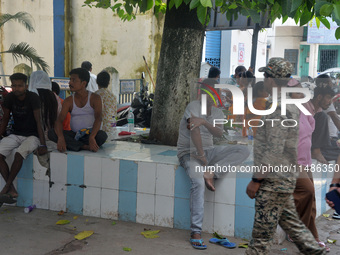 Relatives of the admitted patients are waiting under a tree at the Main Entrance of the busiest Siliguri District hospital in Siliguri, Indi...