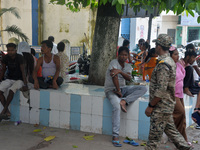 Relatives of the admitted patients are waiting under a tree at the Main Entrance of the busiest Siliguri District hospital in Siliguri, Indi...