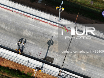 Construction workers are installing overhead contact line poles on the Fuhe River Bridge in the Beijing-Hong Kong High-speed Railway Nanchan...