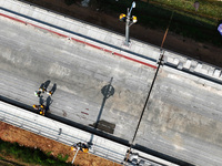 Construction workers are installing overhead contact line poles on the Fuhe River Bridge in the Beijing-Hong Kong High-speed Railway Nanchan...