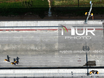 Construction workers are installing overhead contact line poles on the Fuhe River Bridge in the Beijing-Hong Kong High-speed Railway Nanchan...