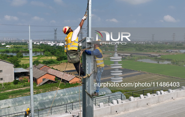 Construction workers are installing overhead contact line poles on the Fuhe River Bridge in the Beijing-Hong Kong High-speed Railway Nanchan...