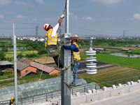 Construction workers are installing overhead contact line poles on the Fuhe River Bridge in the Beijing-Hong Kong High-speed Railway Nanchan...