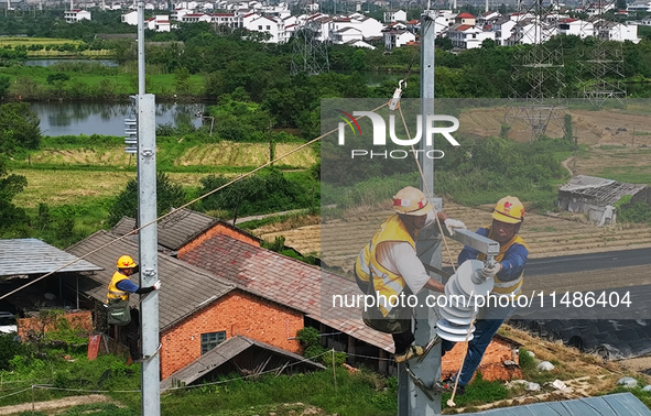 Construction workers are installing overhead contact line poles on the Fuhe River Bridge in the Beijing-Hong Kong High-speed Railway Nanchan...