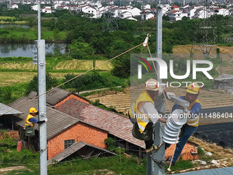 Construction workers are installing overhead contact line poles on the Fuhe River Bridge in the Beijing-Hong Kong High-speed Railway Nanchan...