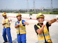 Construction workers are installing overhead contact line poles on the Fuhe River Bridge in the Beijing-Hong Kong High-speed Railway Nanchan...