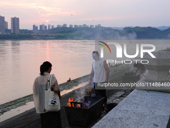 People are burning paper money to offer sacrifices to their ancestors during the Hungry Ghost Festival in Yichang, China, on August 16, 2024...