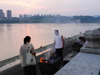 People are burning paper money to offer sacrifices to their ancestors during the Hungry Ghost Festival in Yichang, China, on August 16, 2024...